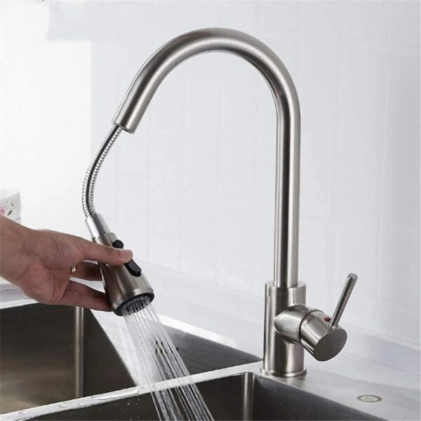 Someone holding kitchen sink tap